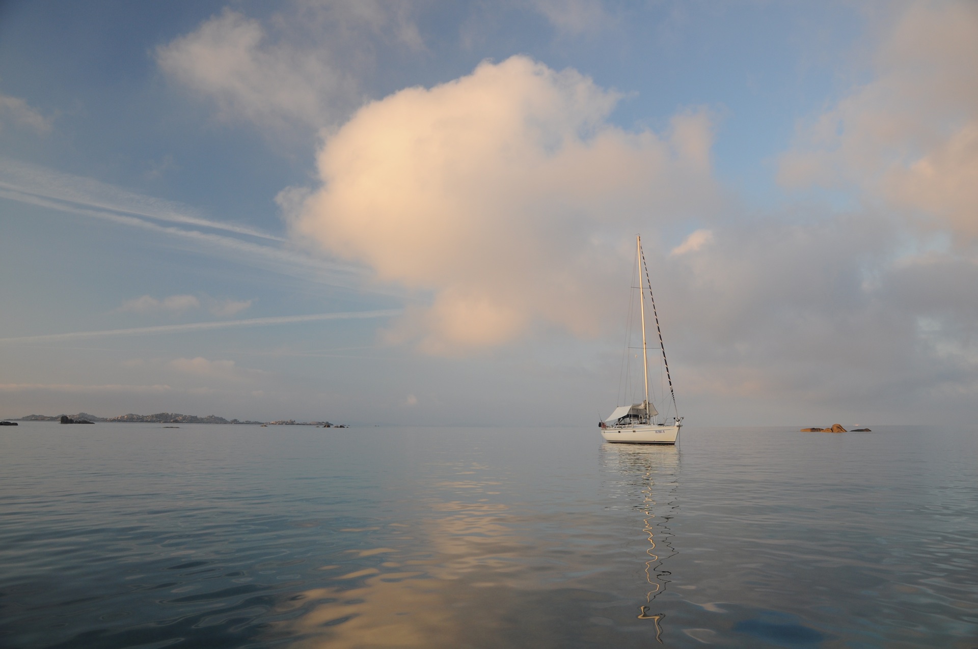 bateau au mouillage aevc des nuages du matin
